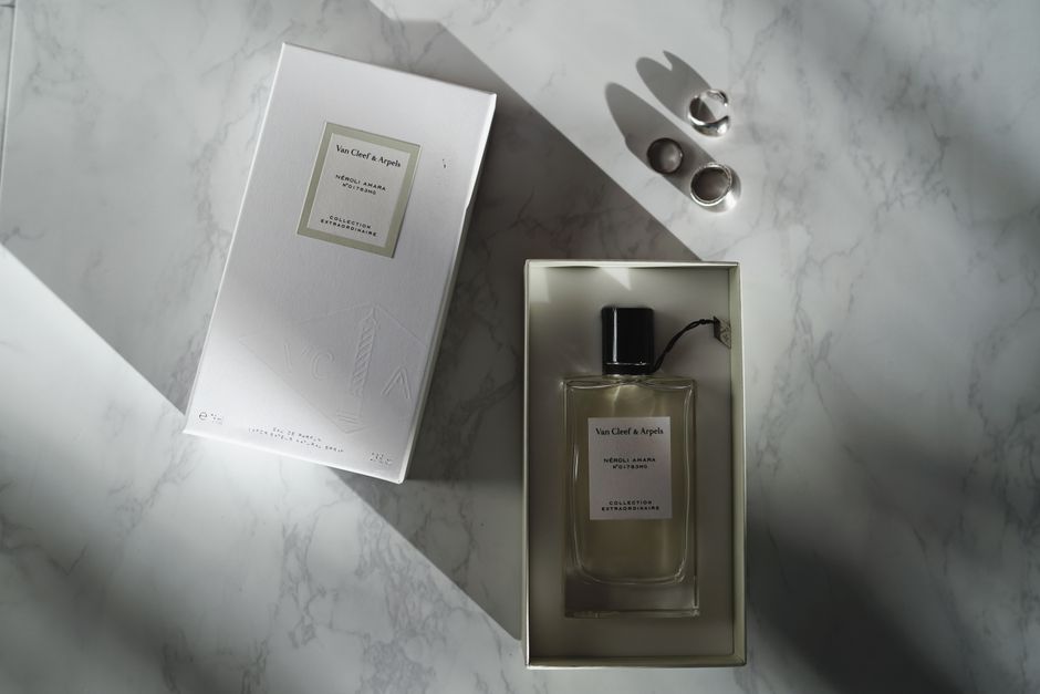 A top view of a luxury perfume bottle and box on a marble surface.
