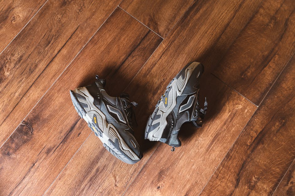 Stylish black sneakers placed on a wooden floor, showcasing modern design and comfort.
