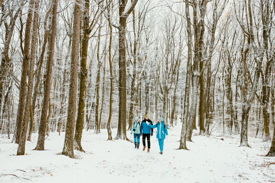 A group of friends hiking through a snow-covered forest in winter.