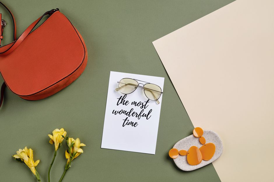 Stylish flat lay of accessories with an inspiring card reading 'the most wonderful time'.
