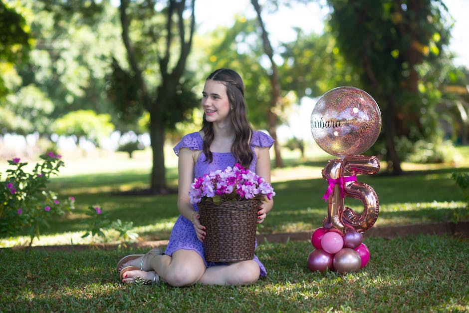 Teen girl enjoying her birthday in a park with flowers and balloons.
