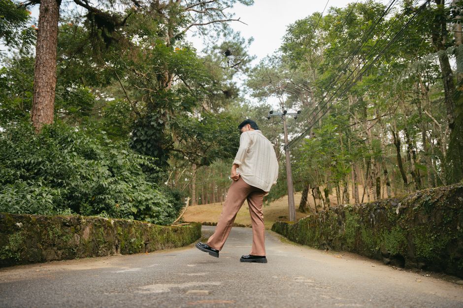 Man strolling down a path in a scenic, lush forested environment.