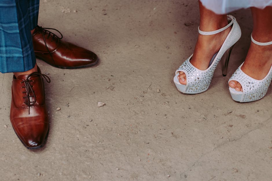 Close-up of elegant men's and women's shoes at a formal event, showcasing style and sophistication.