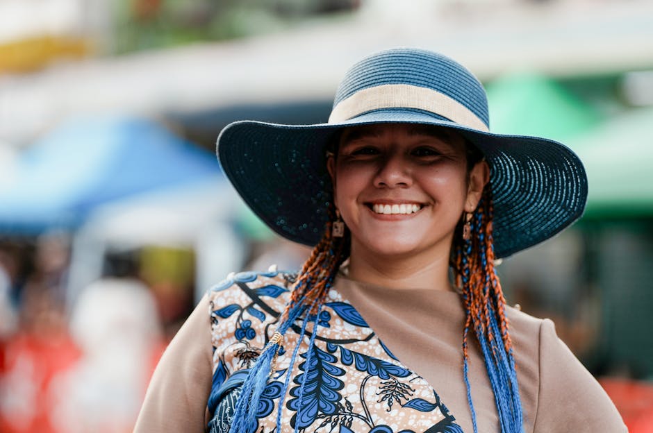Happy woman in a colorful outfit and blue hat, enjoying a sunny day at the market in Limón, Costa Rica.
