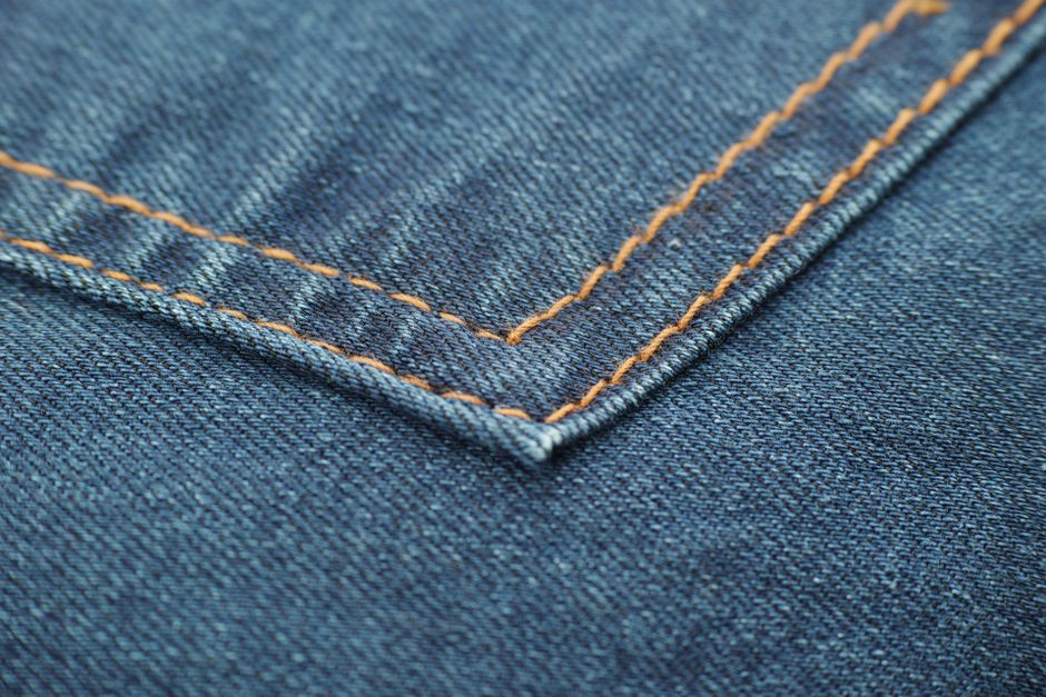 Macro shot highlighting the intricate stitching on blue denim fabric.