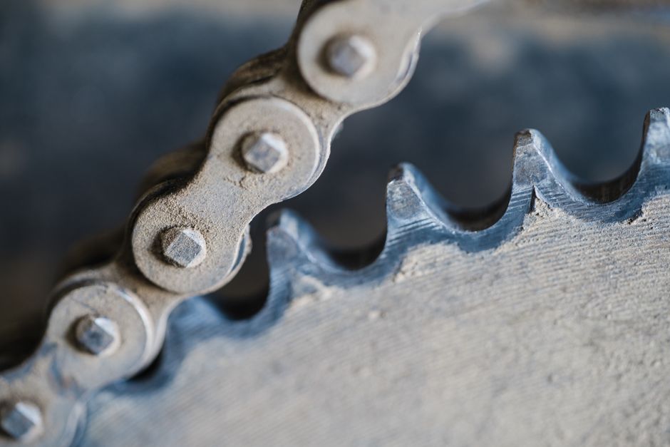 High-resolution macro shot of a metal chain and gear, showcasing industrial machinery detail.