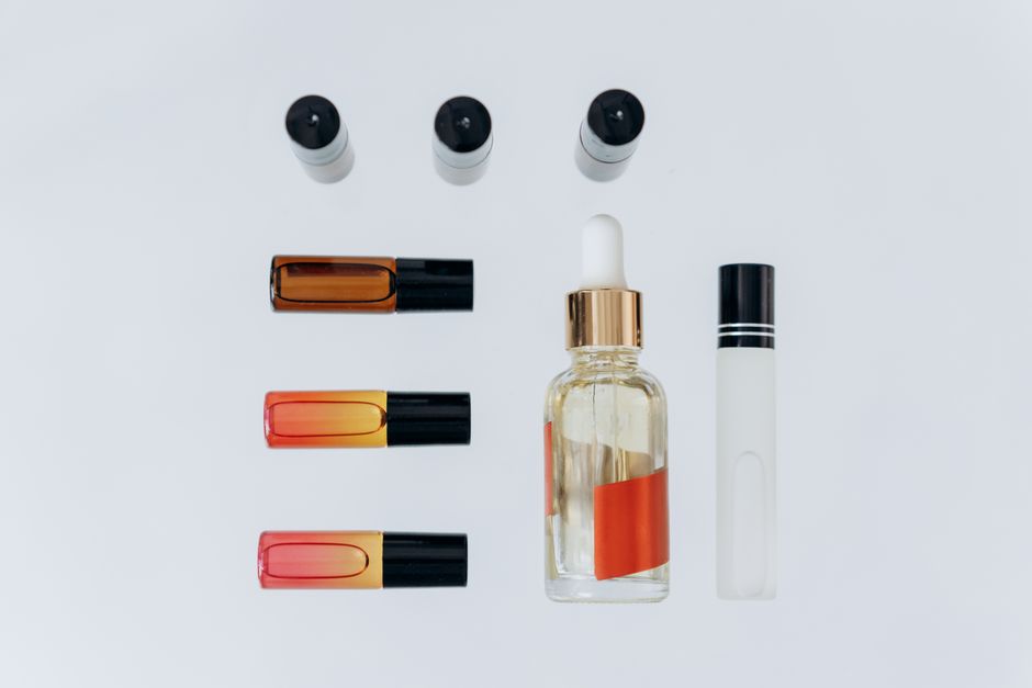 Top view of various aromatherapy oils and bottles arranged on a white background.
