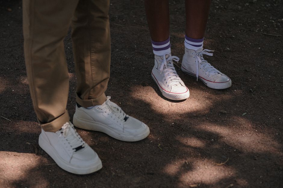 Teenagers wearing Converse sneakers enjoying a sunny day in the park.